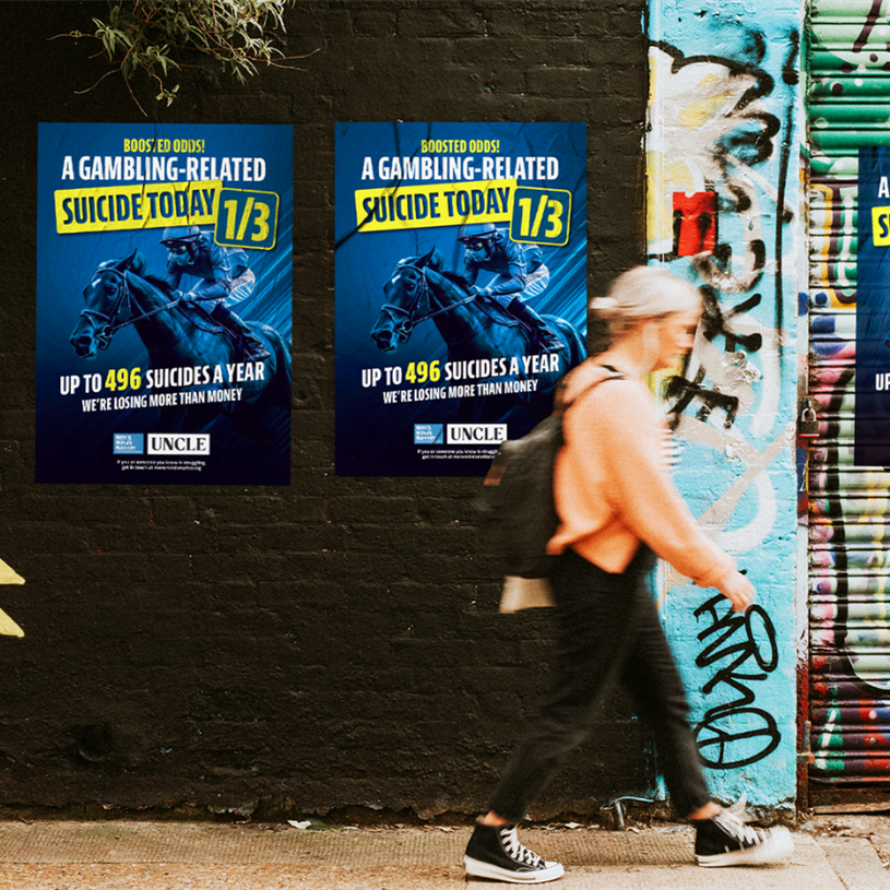 Woman walking past posters of the Men's Minds Matter campaign
